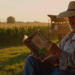 Amish farmer reading a secular book on his farmhouse porch at sunset